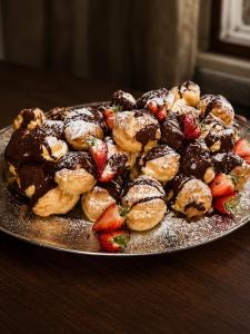 a plate of cookies and strawberries on a table at The Old Manor House Hotel in Keynsham +103 photos