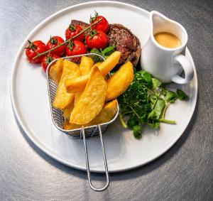 a plate of food with a burger and a cup of coffee at The Old Manor House Hotel in Keynsham