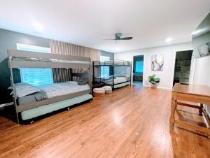 a bedroom with two bunk beds and a wooden floor at Arcade Shuffleboard Poker Firepit Grill @ Battery in Marietta