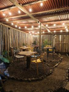 eine Terrasse mit Tischen und Stühlen unter einer Holzdecke in der Unterkunft Hospedaje Rural Shihumar in Coquí