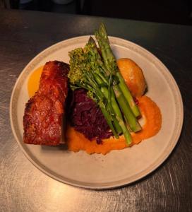 a plate of food with meat and vegetables on a table at The Old Manor House Hotel in Keynsham