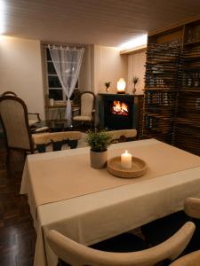 a room with a table with a candle and a fireplace at Hôtel de la Couronne in Les Bois