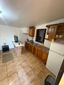 a kitchen with wooden cabinets and a white refrigerator at Vivenda Santos in Albufeira