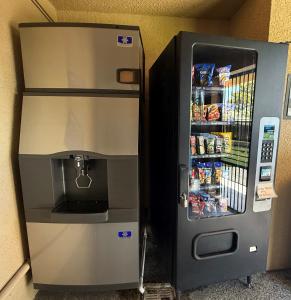 a drink dispenser in front of a refrigerator at Baymont by Wyndham Manteca in Manteca