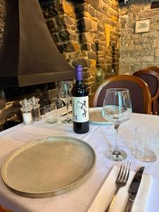 a table with a bottle of wine and glasses on it at The Old Manor House Hotel in Keynsham