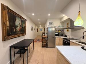 a kitchen with a refrigerator and a table with chairs at The Hudson Horizon in West New York