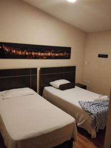 a hotel room with two beds and a painting on the wall at Hotel Platino Plaza in Dosquebradas