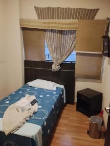 a bedroom with a blue bed with a window at Hotel Platino Plaza in Dosquebradas +1 photo