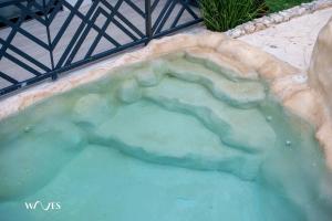 a hot tub filled with blue water in a garden at Spacious Loft with Balcony Near Hotel Zone Palais Tulum by Waves in Tulum