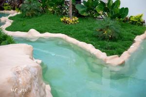 a small pool of water in a yard with grass at Spacious Loft with Balcony Near Hotel Zone Palais Tulum by Waves in Tulum +5 photos