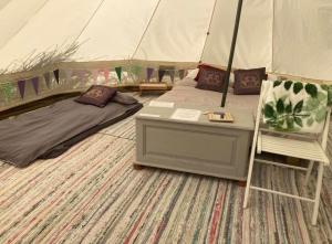 a bed and a table in a tent at Looe Valley Camping in Saint Keyne