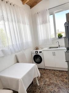 a kitchen with a washing machine and a sink at Villa Murataj in Ksamil +28 photos