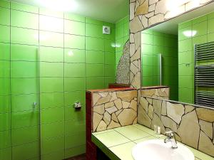 a green bathroom with a sink and a mirror at Hotel Vinopa in Hustopeče +27 photos