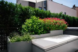 a bench with flowers and plants on a balcony at La Terrazza - Private Jacuzzi in Downtown Como in Como