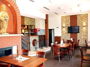 a restaurant with tables and chairs and a fireplace at Hotel Vinopa in Hustopeče