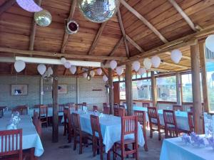 a dining room with tables and chairs and wooden ceilings at Alma Campestre in Brandsen
