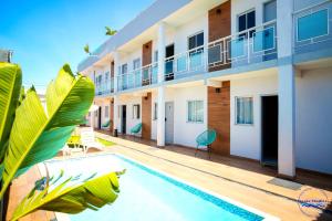 a swimming pool in front of a building at Praia Studios in Vila Velha