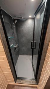 a shower with a glass door in a room at The Joint in Hakuba