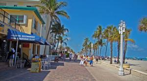 a street with palm trees and people walking on the beach at Comfortable Stay O in Hollywood