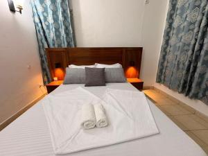 a bedroom with a white bed with towels on it at Le nid des Anges in Yaoundé