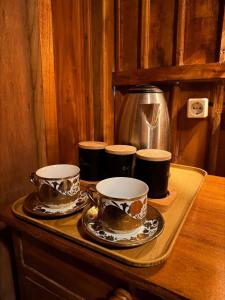 three cups and saucers on a tray on a table at Dopi Rinjani Homestay in Tetebatu