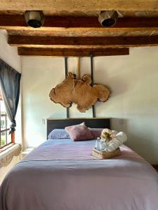 a bedroom with a large bed with a wooden ceiling at Hotel Portal & Suites in Ciudad Hidalgo