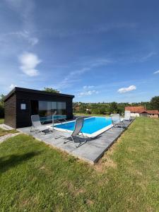 a small house with a swimming pool and chairs at Villa Verdea Lopatinec in Lopatinec