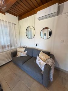 a living room with a blue couch and two mirrors at Villa Verdea Lopatinec in Lopatinec