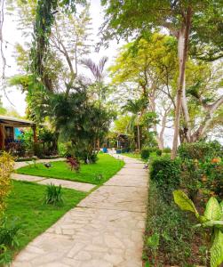 a walkway in a park with trees and grass at Xalli Beach Hotel in Altagracia