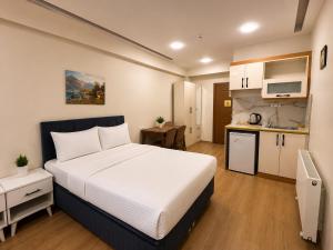 a bedroom with a large bed and a kitchen at ISTANBUL STAY Boutıque Hotel in Istanbul