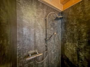a shower in a bathroom with a concrete wall at Rattendorf 13B in Rattendorf +45 photos