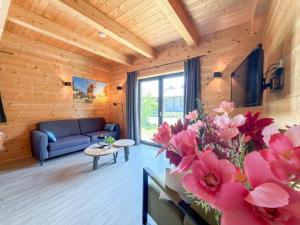 a living room with a blue couch and pink flowers at Rattendorf 13A in Rattendorf