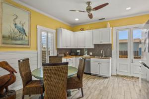 a kitchen with white cabinets and a table and chairs at P Alister Trio in Port Aransas