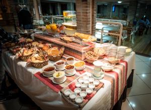 una mesa con un buffet de comida. en Hotel Alles Blau, en Pelotas