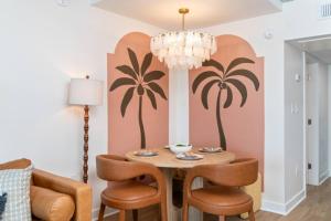 a dining room with a table with chairs and a chandelier at Penthouse Oceanfront Studio VR + Mural + Minibar in Myrtle Beach