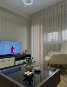a living room with a tv and a table at Apartman Una in Leskovac +16 photos