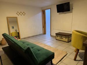 a living room with a green couch and a television at Casa Matia in Guadalajara