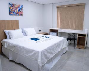 a bedroom with a large white bed with a desk at Il Divo Boutique Hotel in Ciudad del Este +66 photos