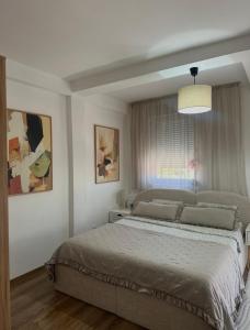 a bedroom with a bed and a pendant light at Apartman Una in Leskovac