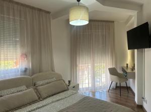 a bedroom with a bed and a chair and a window at Apartman Una in Leskovac