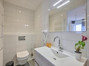 a bathroom with a sink and a toilet and a mirror at Sea Quality 83 in Colijnsplaat +37 photos