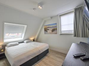 a small bedroom with a bed and two windows at Sea Quality 83 in Colijnsplaat