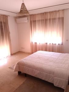 a bedroom with a large white bed and curtains at L'hivernage andalouse 4 in Marrakesh +16 photos