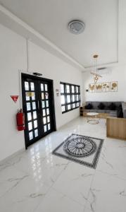 a white living room with a large marble floor at Sekuto Inn by Sawala in Tegal