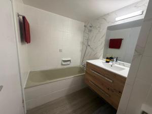 a bathroom with a green tub and a sink and a shower at The Seafront Pearl in Larnaca