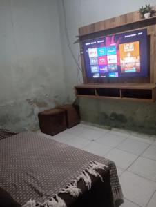 a room with a tv and a bed in front of it at Casa simples e aconchegante in Campina Grande