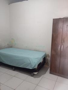 a bedroom with a bed and a wooden cabinet at Casa simples e aconchegante in Campina Grande