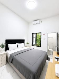 a bedroom with a large bed and a bathroom at Sekuto Inn by Sawala in Tegal