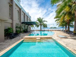 a swimming pool at a hotel with a view of the ocean at Swiss-Belhotel Papua in Jayapura