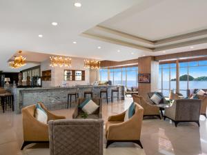 a lobby with chairs and a bar with a view at Swiss-Belhotel Papua in Jayapura